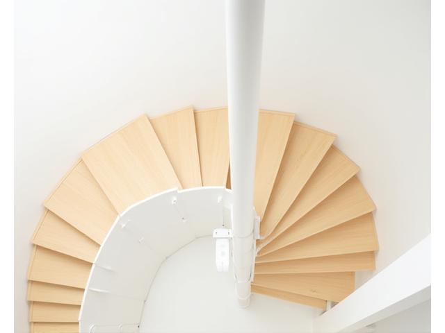 Escalier en colimaçon moderne avec marches en bois clair et structure métallique